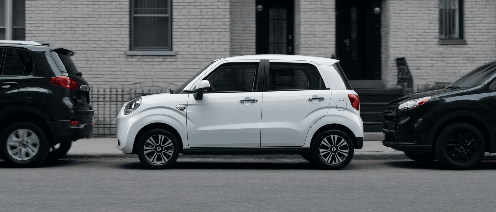The Wink Mark3 parked at the kerb between two full-size SUVs